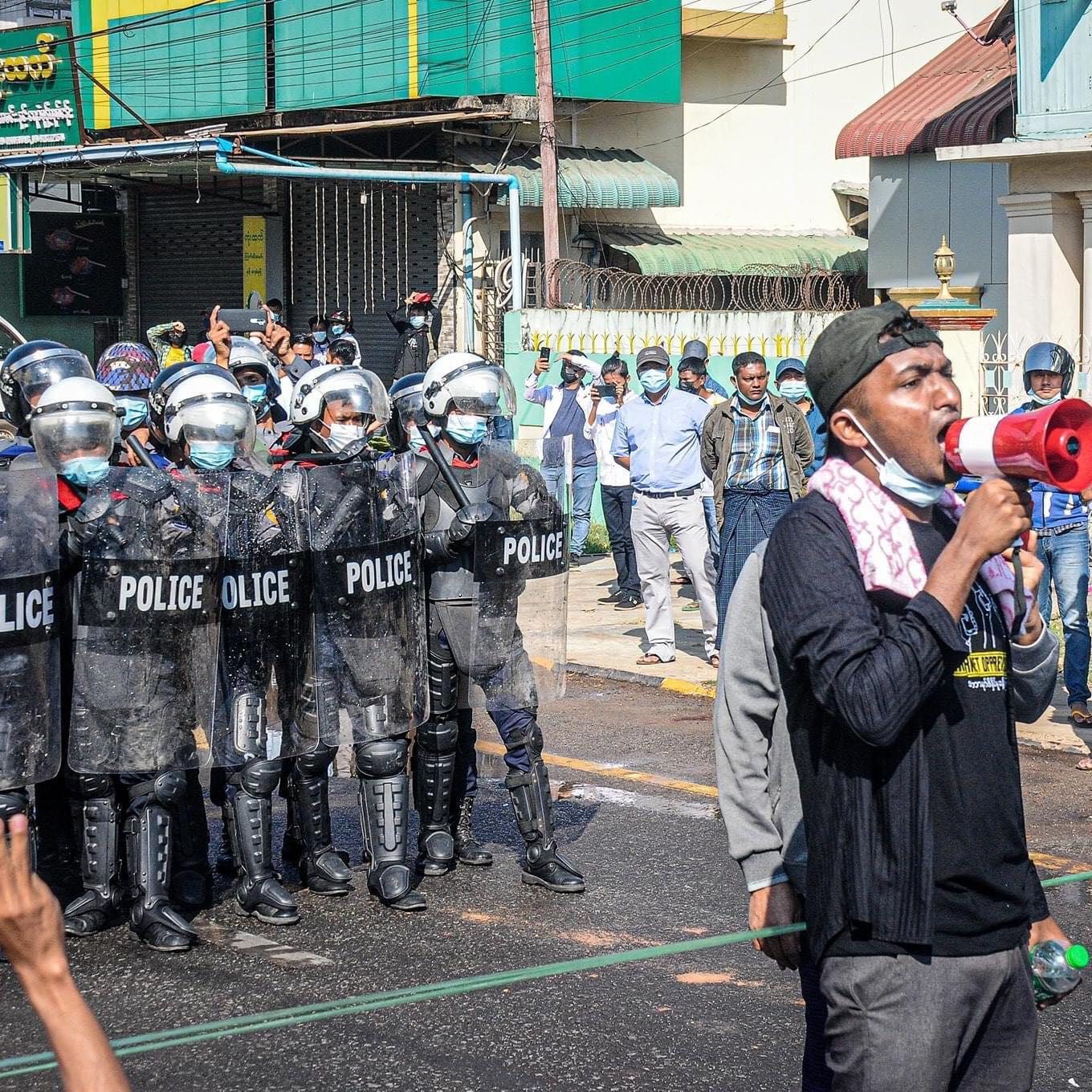 Anti-coup protester strike in front of Police guard