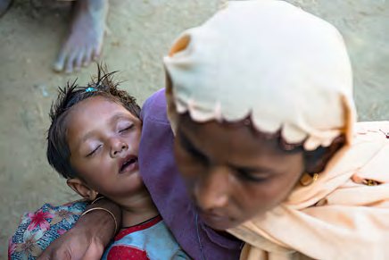 A Rohingya woman holding a sleeping child